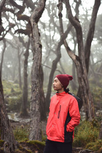 Side view of woman standing in forest