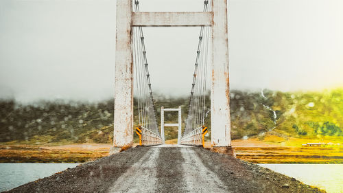 Road by bridge against sky