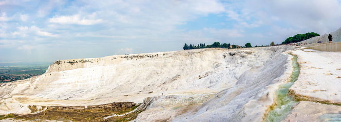 Panoramic view of rocks on shore against sky