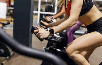 Close-up of woman on spinning bike in the gym