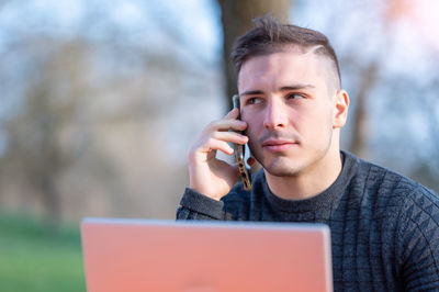 Man looking away while talking on smart phone