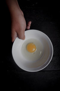 Hands hold a bowl of chicken eggs