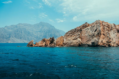 Scenic view of sea and mountains against sky