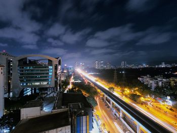 High angle view of light trails on road amidst buildings in city