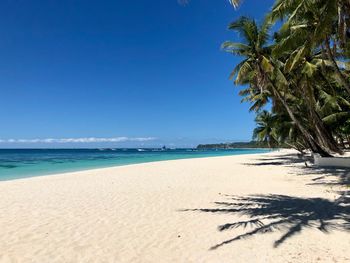 Scenic view of beach against clear blue sky