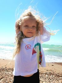 Portrait of girl with tousled hair standing at beach