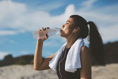 Young woman drinking water bottle