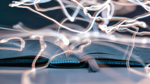 Double exposure of book and light trail on table