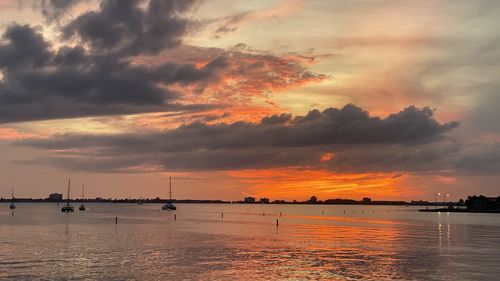 Scenic view of sea against dramatic sky during sunset