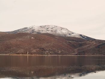 Scenic view of lake by mountains against sky