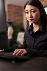 Portrait of young woman using laptop at home