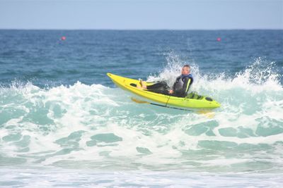 Man surfing in sea against clear sky