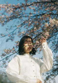 Portrait of girl standing by cherry tree