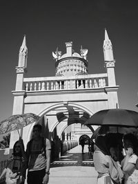 Group of people in front of building against sky