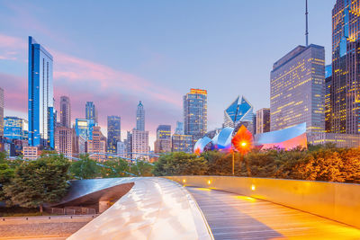 Illuminated buildings in city against sky