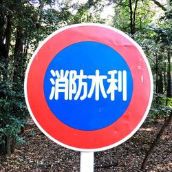 Close-up of road sign against blue sky