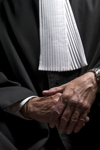 Midsection of lawyer standing against black background