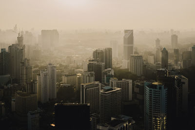 Aerial view of buildings in city against sky