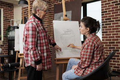 Side view of female friends using digital tablet