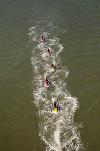 High angle view of people jet boating in sea