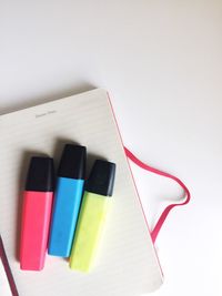 Directly above shot of highlighters on diary against gray background