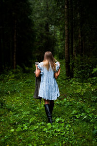 Rear view of woman standing in forest