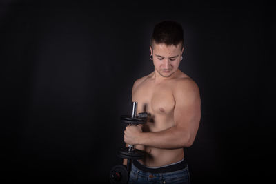 Young man looking away against black background