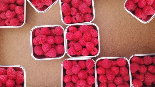 High angle view of raspberries in boxes on table