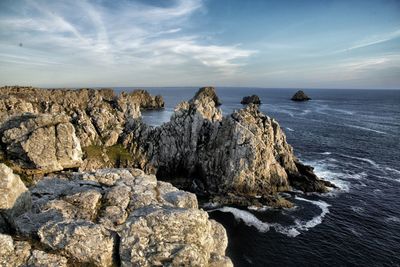 Scenic view of rocky beach against sky