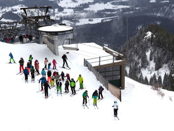 High angle view of people skiing on snow covered hill during winter