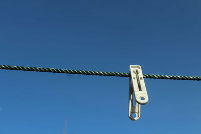 Low angle view of rope against clear blue sky