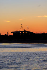 Silhouette ship on sea against sky during sunset