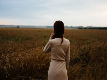 Rear view of woman standing in field