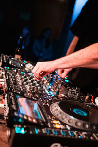 Midsection of man playing songs at nightclub