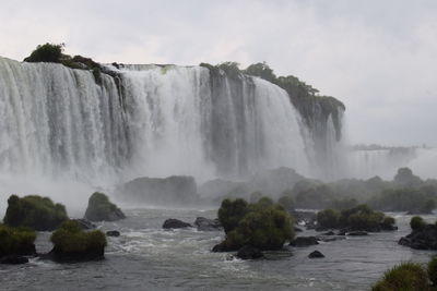 Scenic view of waterfall against sky
