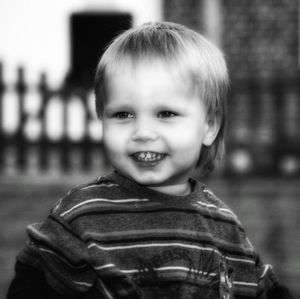 Smiling cute boy looking away while standing outdoors