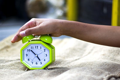 Close-up of human hand on alarm clock