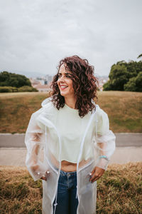 Beautiful woman looking away standing against sky