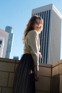 Young woman standing against building