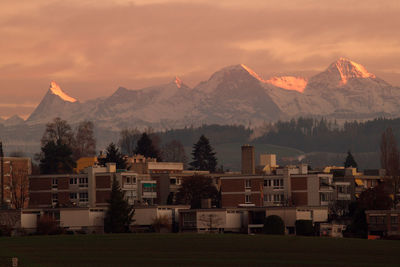 Houses and townscape against mountains during sunset
