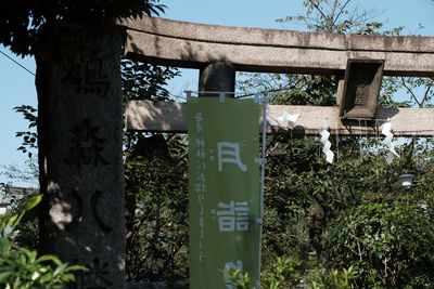 Low angle view of information sign against trees