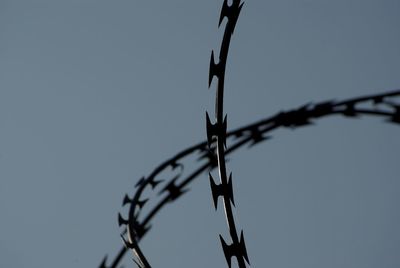 Low angle view of barbed wire against clear sky