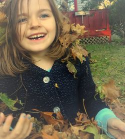 Portrait of smiling young woman eating in greenhouse
