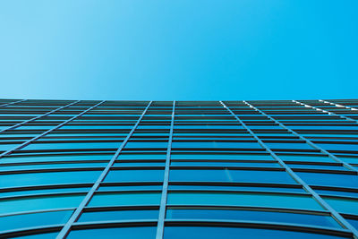 Low angle view of modern building against clear blue sky