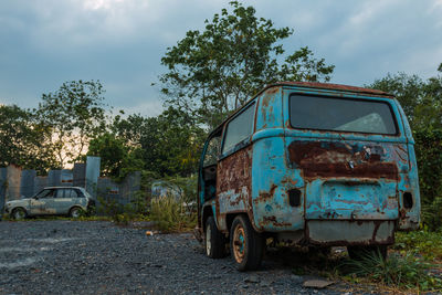 Abandoned vehicles against trees