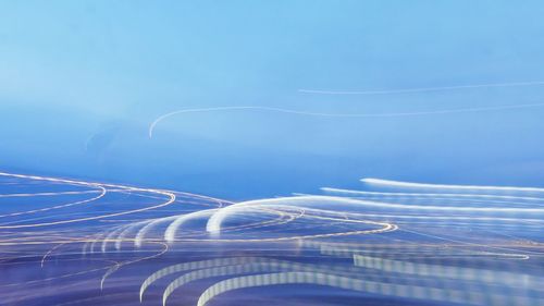 Close-up of light trails against blue sky