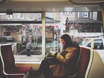 Side view of woman sitting in bus