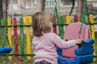 Girl holding swing at playground