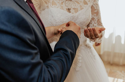 Midsection of bride holding wedding dress