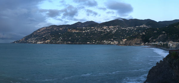 Scenic view of sea and mountains against sky